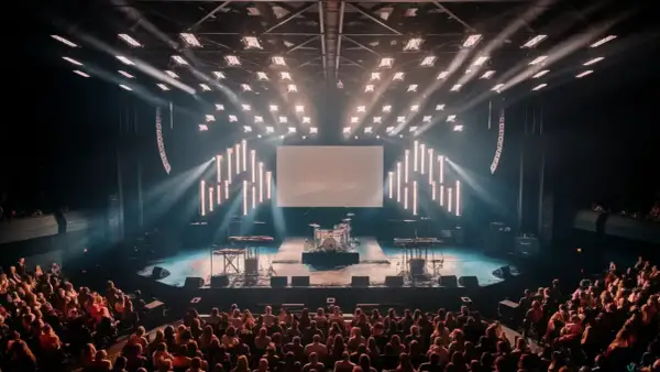 An empty concert stage with drums and keyboards awaits the band. The audience is seated, ready for the show to begin, and wondering what is the average length of a concert.