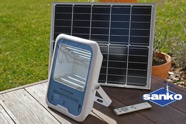 Lampa solarna i panel słoneczny na drewnianym tarasie. Dowiedz się, jak naładować lampę solarną bez słońca, korzystając z alternatywnych metod ładowania.