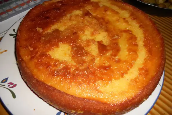 Un délicieux cake à l'orange, doré et moelleux, prêt à être dégusté. Sa croûte caramélisée promet une explosion de saveurs.