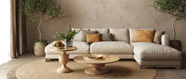 Accogliente salotto con divano chiaro, cuscini ocra e verdi, tavolini in legno e piante. Un'atmosfera rilassante con salotto colori caldi.