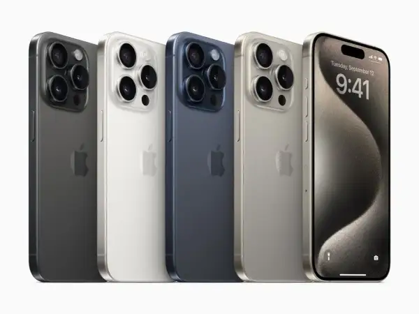Pięć iPhone'ów w różnych kolorach: grafitowy, biały, granatowy, złoty i jeden z włączonym ekranem, prezentujący datę i godzinę.