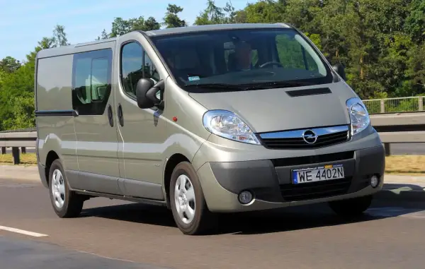 Opel Vivaro w kolorze szampańskim na drodze. Kierowca i pasażer w środku. Zastanawiasz się nad opel vivaro spalanie?