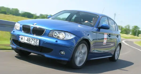 Niebieskie BMW e81 z polskimi tablicami WI 4875E na zakręcie toru wyścigowego.