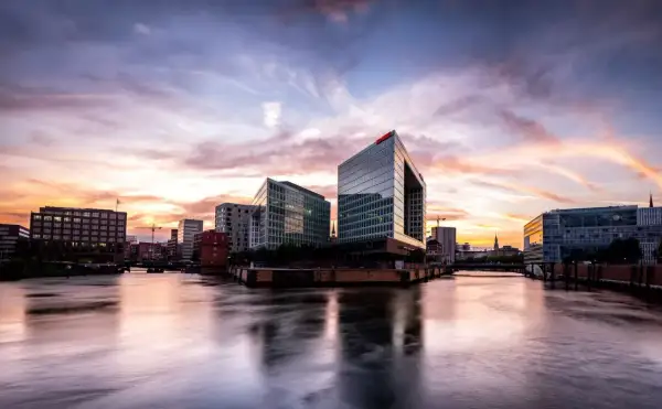 Spektakulärer Sonnenuntergang über Hamburgs moderner Architektur. Ein perfekter Ort für Fotospots Hamburg, mit Spiegelungen im Wasser.