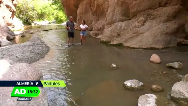 Dos personas caminan por un río en un cañón, explorando qué ver en Padules, Almería.