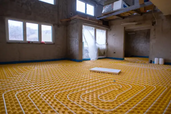 Installazione di un sistema di riscaldamento a pavimento, un'avanzata forma di aria condizionata a pavimento, in un edificio in costruzione.
