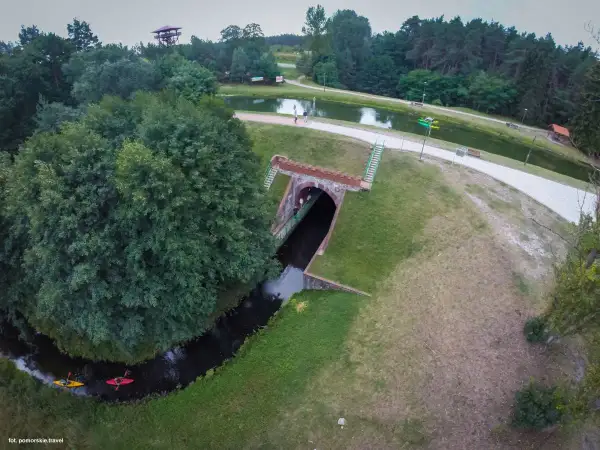Akwedukt w Fojutowie, gdzie rzeka przepływa pod ziemią, a nad nią rozciąga się malowniczy park z jeziorem i wieżą widokową.