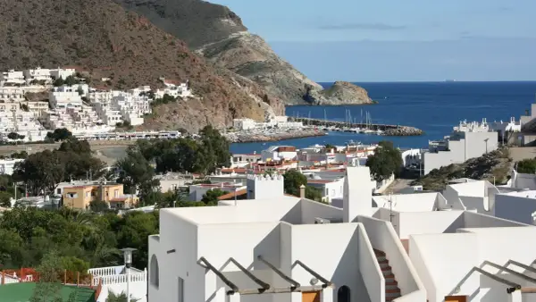 Vista de la bahía de San José, con sus casas blancas y el puerto deportivo. El paisaje de **4 nudos cabo de gata** se extiende hasta el mar azul.