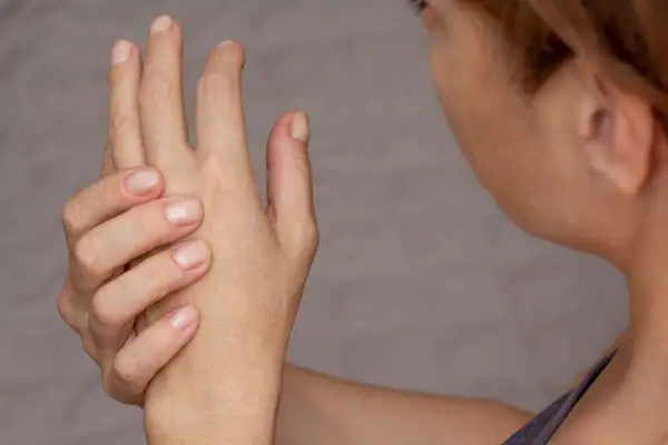 Mano che si tiene, con dita piegate, per alleviare il dolore alle falangi delle mani.