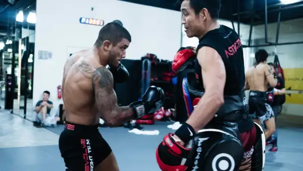 Fighter throws an uppercut punch during a training session in a gym.