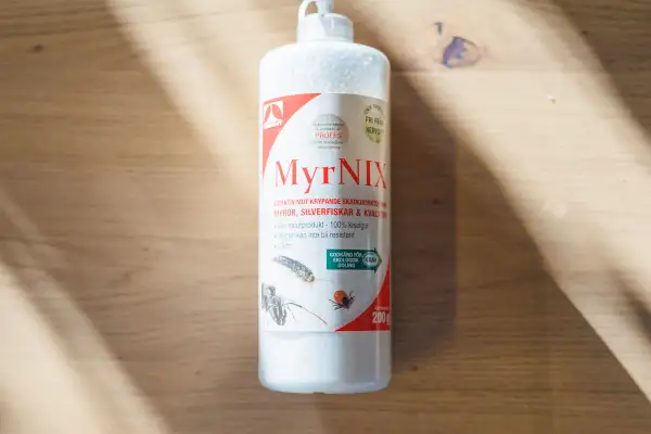 Flaska med MyrNIX, ett naturprodukt baserat på kiselgur, effektivt mot krypande skadeinsekter.