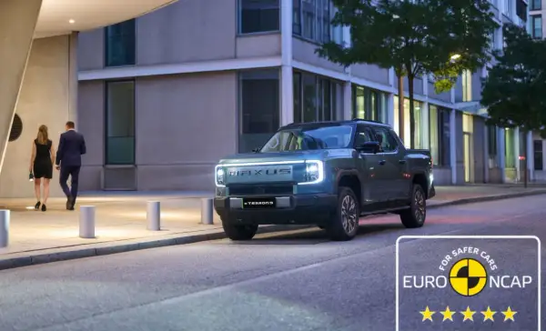 Elegancka para idzie obok nowoczesnego, elektrycznego pickupa Maxus eTerron9. Auto zdobyło 5 gwiazdek w testach Euro NCAP.