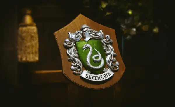 Herb Hogwartu, herb Slytherinu z zieloną tarczą i srebrnym wężem, dumnie prezentuje swoje barwy.
