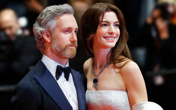 Anne Hathaway z mężem Adamem Shulmanem na czerwonym dywanie. Ona w olśniewającej sukni i biżuterii, on w eleganckim smokingu.