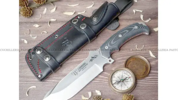 Cuchillo Cudeman Entresierras con funda de cuero, brújula y detalles de naturaleza. Ideal para aventuras.