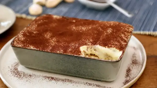 Un délicieux tiramisu pour 4 personnes, saupoudré de cacao, prêt à être dégusté.
