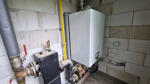 Piec Ferroli jak ustawić? Widok instalacji gazowej i wodnej przy kotle.