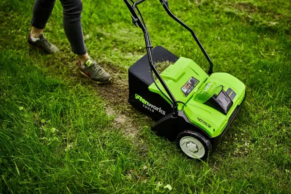 Zielona glebogryzarka Greenworks z koszem na trawę, gotowa do pracy w ogrodzie. To narzędzie, które pomoże Ci zadbać o trawnik.