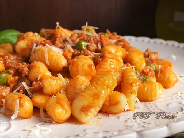 Gnocchetti sardi con ragù e piselli, un piatto gustoso ispirato alle ricette della Sardegna.