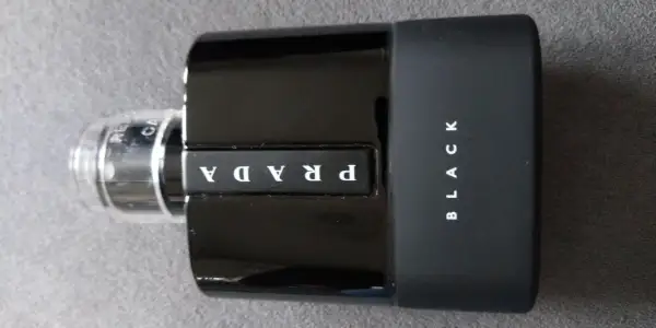 Elegancka, czarna butelka perfum Prada Black z białym logo.