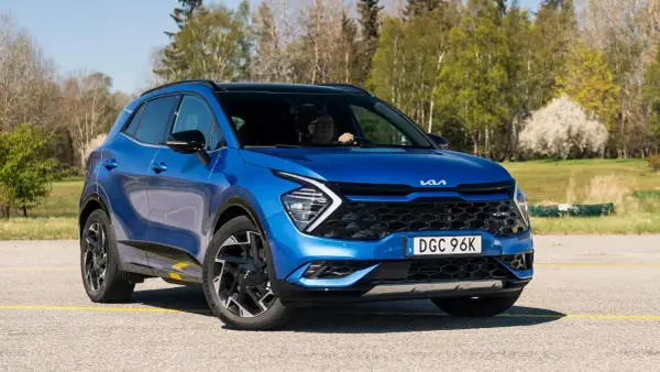 Blå Kia Sportage, en begagnad bil som testas i soligt vårväder.