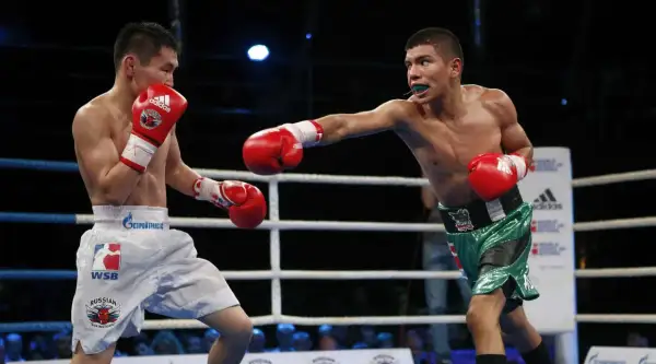 Two boxers exchange punches in the ring. The boxer on the right throws a jab, while the boxer on the left defends. The outcome of this fight, like many, will be decided by how many judges in boxing score the rounds.