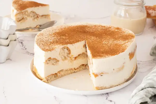 Tarta de horchata y fartons, cremosa y espolvoreada con canela. Una porción ya servida.