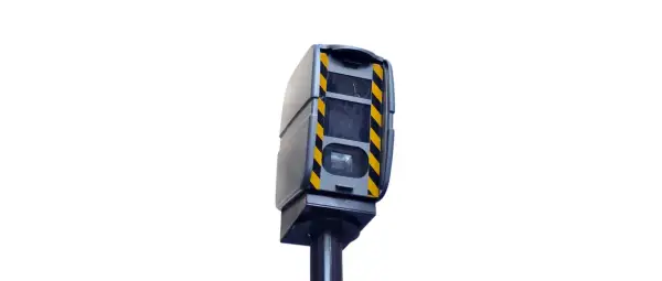 Boîtier gris avec bandes noires et jaunes, monté sur un poteau. Ce radar de contrôle de vitesse est un modèle différent de ceux que l'on voit habituellement.