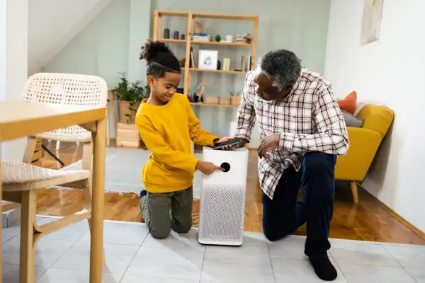 A boy and his grandfather learn how to test air quality in your home using a modern air purifier.