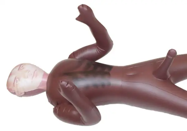 Nadmuchiwana lalka z penisem, leżąca na plecach, z nadrukowaną twarzą na głowie.