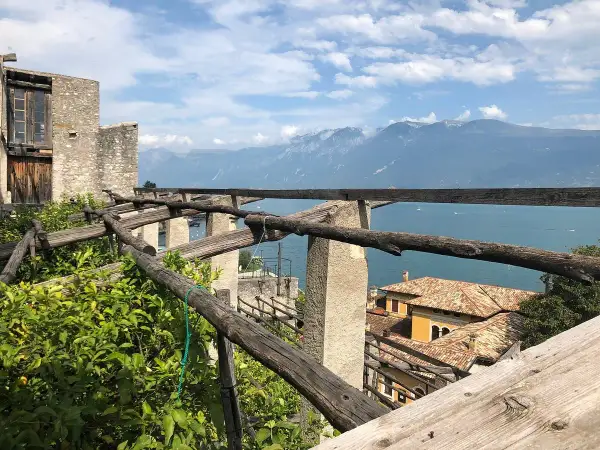 La **limonaia la malora** domina il lago, con le sue strutture in legno e le montagne sullo sfondo.