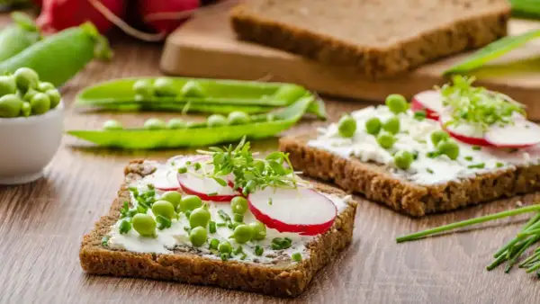 Frisches Vollkornbrot mit Frischkäse, Erbsen, Radieschen und Kresse – ein gesunder Aufschnitt für jeden Tag.