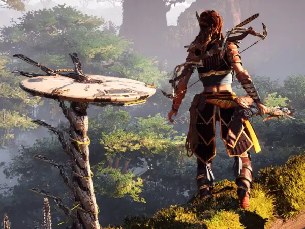 Aloy z łukiem stoi na wzgórzu, patrząc na maszynę w lesie. To kluczowy moment w Horizon Zero Dawn poradnik.