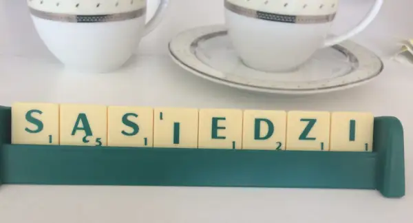 Litery z gry planszowej układają się w napis "SĄSIEDZI". Może to być art. 107 zakłócanie spokoju, gdy sąsiad jest głośny.