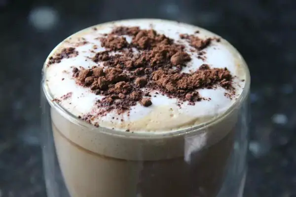 Cappuccino con schiuma soffice e cacao in polvere, un esempio di come montare il latte senza montalatte per un caffè perfetto.