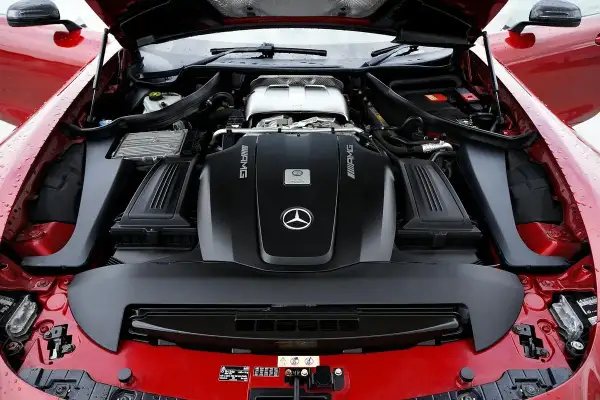 Le capot ouvert révèle le puissant moteur AMG d'une Mercedes rouge. Ce moteur, bien que différent d'un moteur Renault, est une merveille d'ingénierie.