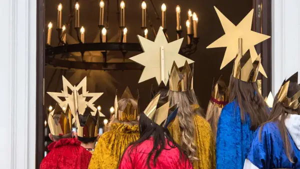 Sternsinger in goldenen Kronen und bunten Gewändern, bereit für den 7. Januar, das Weihnachtsfest.