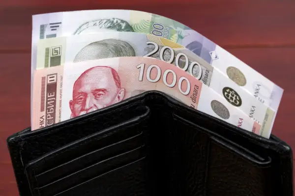 Czarny portfel wypełniony banknotami serbskie dinary. Widać nominały 1000 i 2000 dinarów.