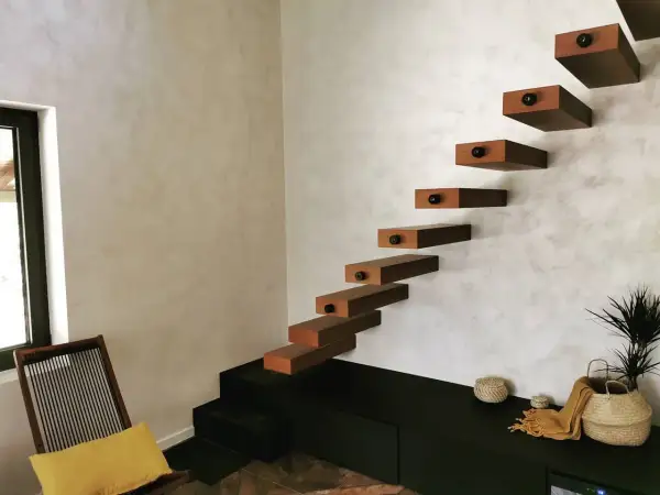 Escaliers flottants en bois sur un mur texturé, une belle deco peinture murale moderne.