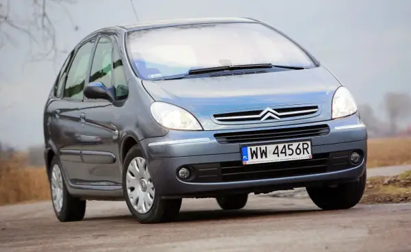 Szary Citroën Xsara Picasso z polskimi tablicami rejestracyjnymi WW 4456R jedzie po drodze.