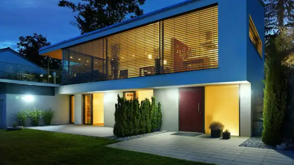 Nowoczesny dom z dużymi oknami, piękne oświetlenie budynku podkreśla jego architekturę.