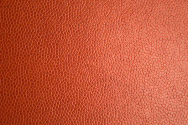 Texture d'un ballon de basket orange. Pour savoir si c'est du vrai cuir, observez la régularité des alvéoles.