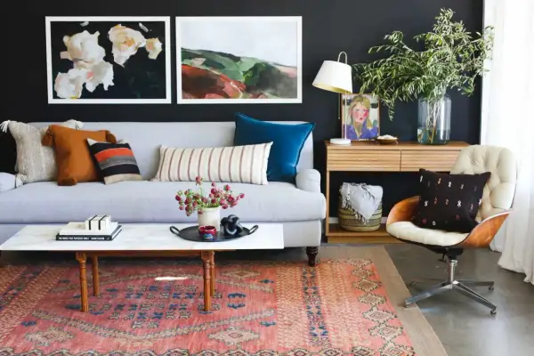Ideas on how to decorate a coffee table: a marble-top table with books, a tray with flowers, and a decorative object.