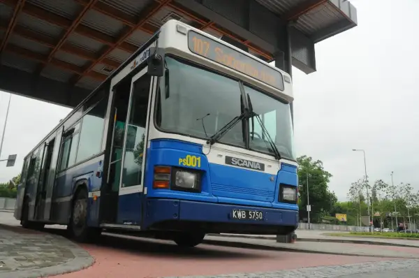 Niebiesko-biały autobus miejski z numerem 107 "Sabanowice" na pętli autobusowej.