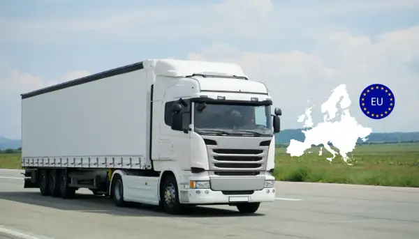 Un camion blanc, d'une hauteur d'un poid lourd, roule sur une route. L'Europe et le drapeau de l'UE sont superposés en arrière-plan.