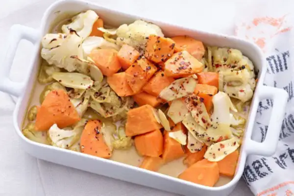 Gebackener Blumenkohl und Süßkartoffeln in einer Auflaufform, ein köstliches Gericht für clean eating rezepte.