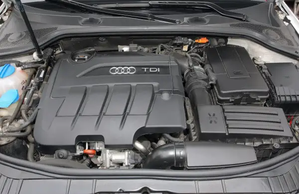 Silnik TDI w Audi A3. Widoczny czarny, plastikowy dekiel z logo Audi i napisem TDI.