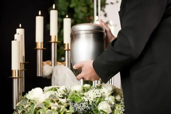 Uroczyste miejsce, gdzie można rozsypać prochy po kremacji, z urną, świecami i kwiatami.