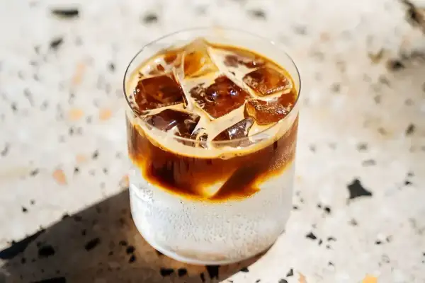 Orzeźwiająca kawa z tonikiem, z kostkami lodu i ciemnym espresso, idealna na upalny dzień.