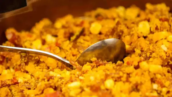 Migas aragonesas, un plato tradicional con trozos de pan, huevo y chorizo, listo para servir con una cuchara.
